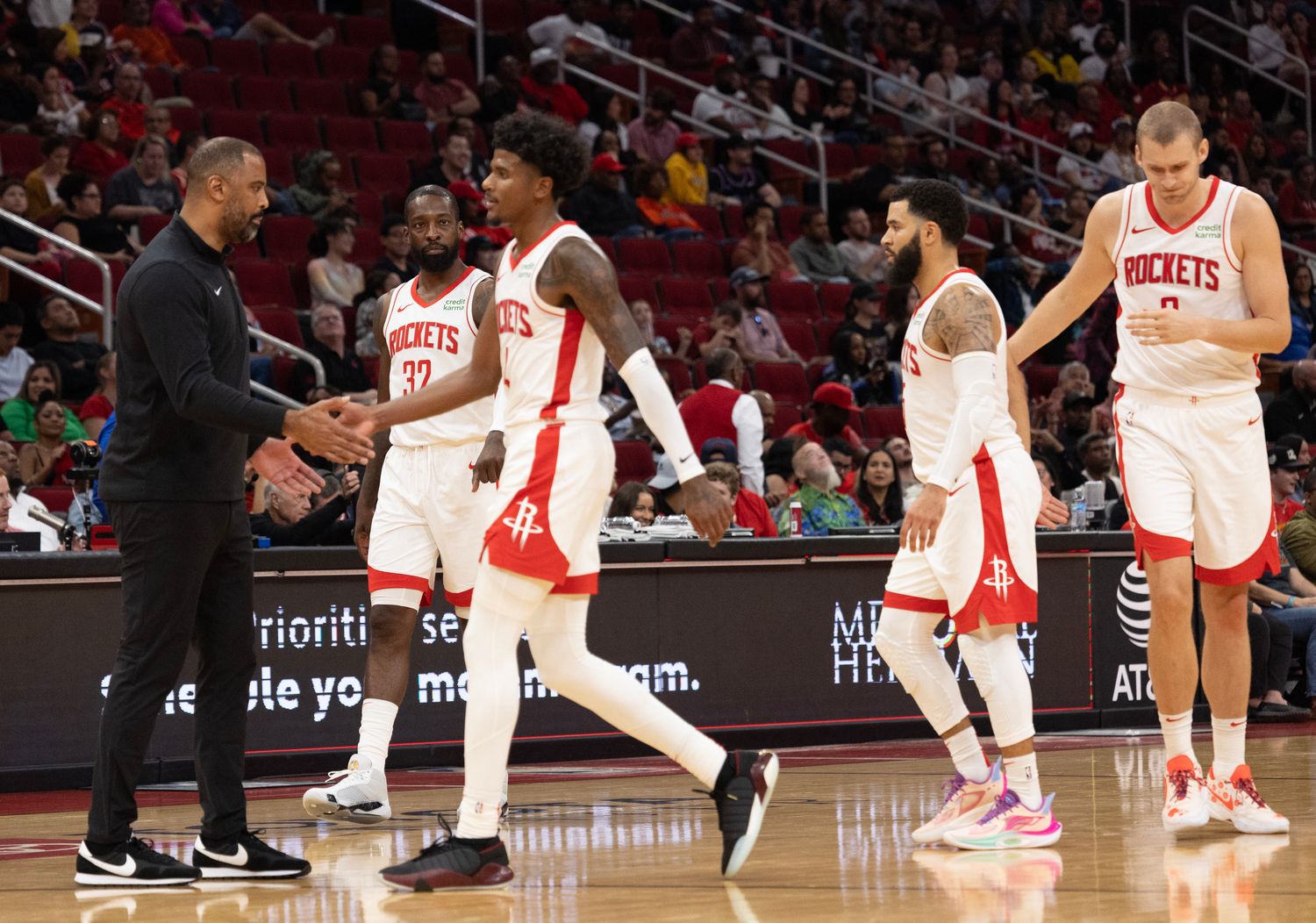 Rockets head coach Ime Udoka low fives Houston Rockets guard Jalen Green after the Miami Heat called timeout.
